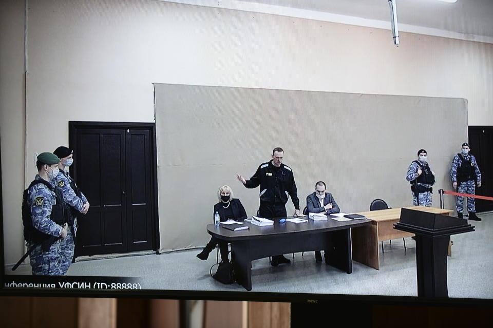 In this image provided by the Russian Federal Penitentiary Service, Russian opposition leader Alexei Navalny speaks via a video link, as he stands next to his layers during a court session in Pokrov, Vladimir region, about 100 kilometers (62 miles) east of Moscow, Russia, Monday, Jan. 17, 2022. A new trial against Russian opposition leader Alexei Navalny opened Tuesday, Feb. 15, 2022, at the penal colony where he faces another lengthy prison term, a further step in a yearlong, multi-pronged crackdown on Russia's most ardent Kremlin critic, his allies and other dissenting voices. (AP Photo/Denis Kaminev)