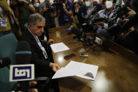 Cardinal Angelo Becciu shows a document as he talks to journalists during press conference in Rome, Friday, Sept. 25, 2020. The powerful head of the Vatican's saint-making office, Cardinal Angelo Becciu, has resigned from the post and renounced his rights as a cardinal amid a financial scandal that has reportedly implicated him indirectly. (AP Photo/Gregorio Borgia)