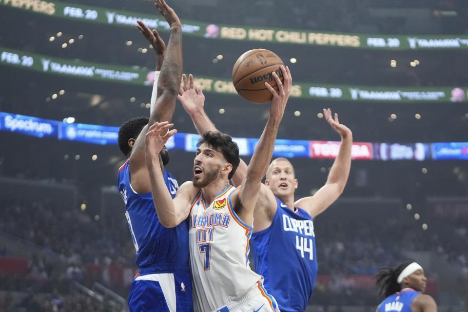 Oklahoma City Thunder forward Chet Holmgren, center, shoots as Los Angeles Clippers forward Paul George, left, and center Mason Plumlee defend during the first half of an NBA basketball game Tuesday, Jan. 16, 2024, in Los Angeles. (AP Photo/Mark J. Terrill)