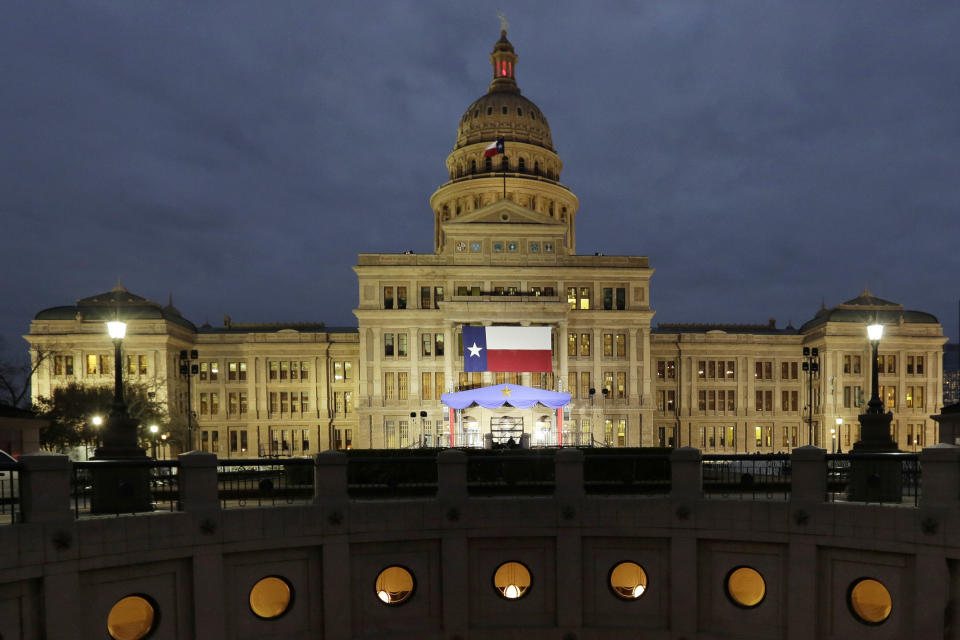FILE - In this Jan. 14, 2019 file photo, a large Texas flag hangs from the Texas State Capitol as workers prepare the grounds for inauguration ceremonies in Austin, Texas. On Friday, May 10, 2019, The Associated Press has found that stories circulating on the internet that a proposed Texas Senate prohibits drivers from transporting groups of "elderly, disabled or poor" to the polls to vote, are untrue. (AP Photo/Eric Gay)