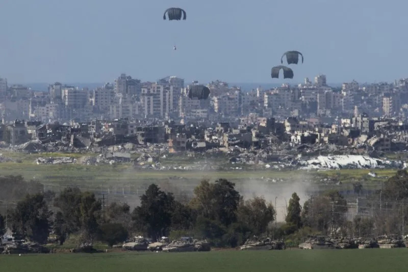 A U.S. Air Force C-130 drops humanitarian aid by parachute over the northern Gaza Strip as seen from inside southern Israel on March 10, 2024. An attack on a food distribution point in Gaza City Thursday killed 21 and wounded at least 150 others. Photo by Jim Hollander/UPI