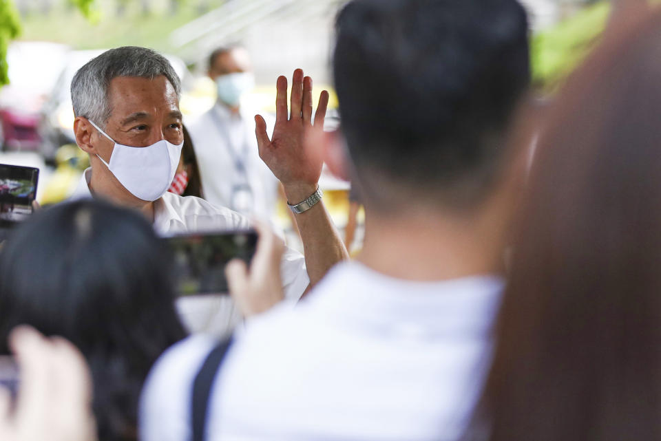 People's Action Party Secretary-General and Singaporean Prime Minister Lee Hsien Loong, left, arrives at a nomination center with his team to submit their nomination papers ahead of the general election in Singapore, Tuesday, June 30, 2020. Campaigning began Tuesday for Singapore's general elections, with the opposition hoping to dent the ruling party's supermajority in parliament with support from Prime Minister Lee's estranged younger brother. (AP Photo/Yong Teck Lim)