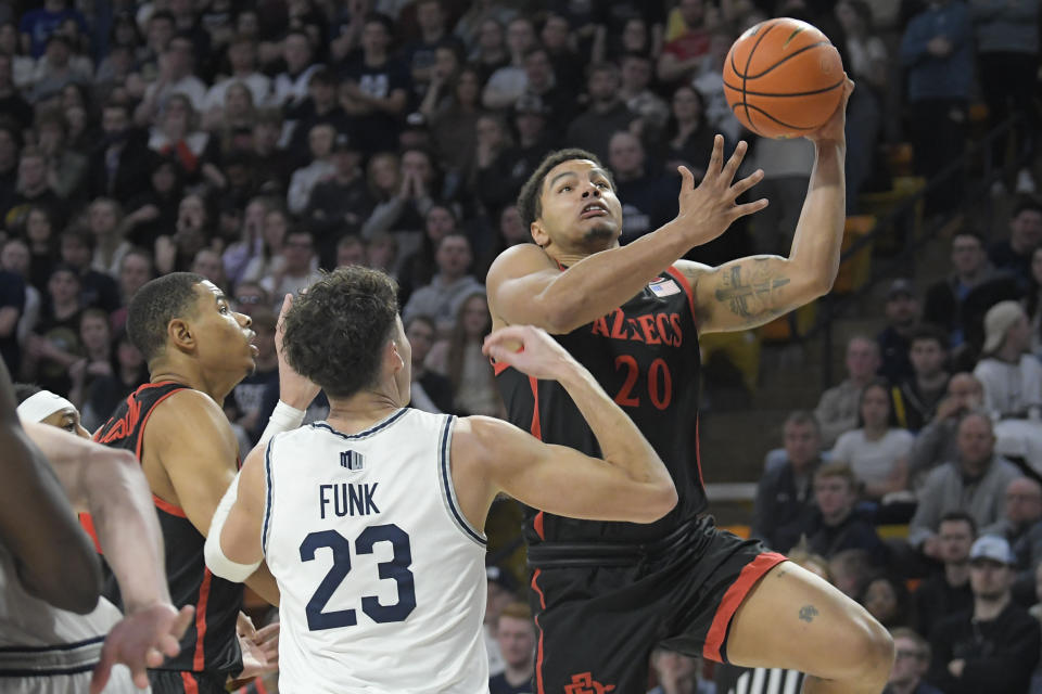 San Diego State guard Matt Bradley (20) drives to the basket as Utah State forward Taylor Funk (23) defends during the first half of an NCAA college basketball game Wednesday, Feb. 8, 2023, in Logan, Utah. (AP Photo/Eli Lucero)