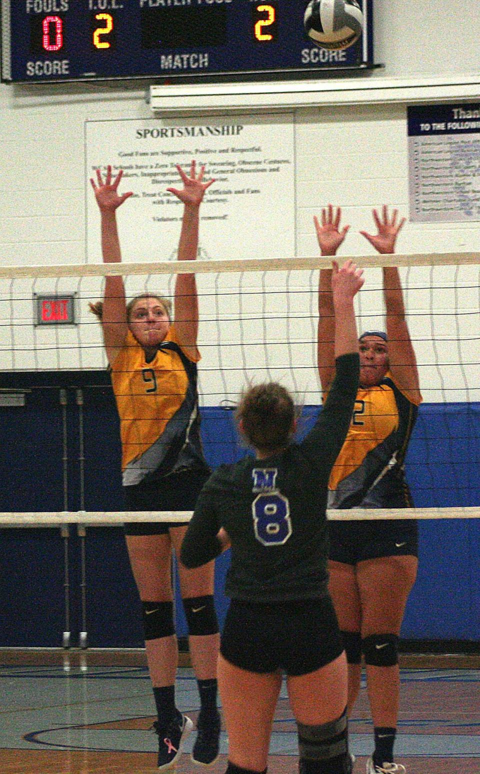 Hillsdale High School's Belle Dalton (9) and Emily McGovern (2) reach up to defend a shot from Northwestern during volleyball action at Northwestern High School Tuesday, Oct. 6, 2020.