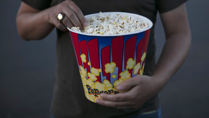 A moviegoer eats popcorn at Mission Tiki drive-in theater in Montclair, Calif., on Thursday, May 28, 2020.