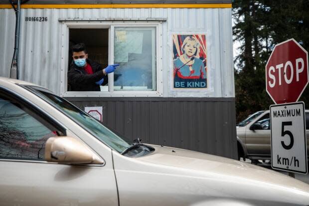 A health-care worker directs traffic at a drive-through clinic in Central Park in Burnaby on March 26. B.C. has seen an alarming increase in COVID-19 cases in recent weeks. (Ben Nelms/CBC - image credit)