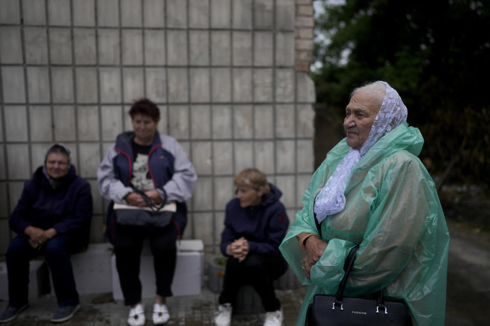 A woman waits in line for social help in Makariv, on the outskirts of Kyiv, Ukraine, Tuesday, June 14, 2022. (AP Photo/Natacha Pisarenko)