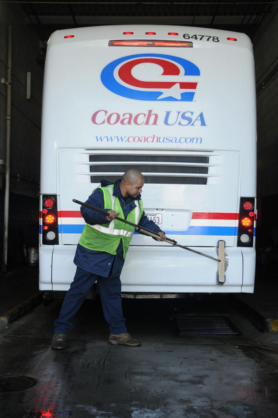 Cesar Castro cleans the back of a charter bus from Coach USA in preparation for a trip to Washington D.C. on Jan. 15, 2009.