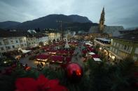 An overview of the Christmas market in Bolzano, northern Italy, Friday, Nov. 26, 2021. After nearly two years of being restricted to watching snow accumulate on distant mountains, Italian skiers are finally returning to the slopes that have been off limits since the first pandemic lockdown in March 2020. But just as the industry is poised to recover from a lost 2020-2021 season after an abrupt closure the previous year, a spike in cases in the Alpine province bordering Austria is underlining just how precarious the situation remains. (AP Photo/Luca Bruno)