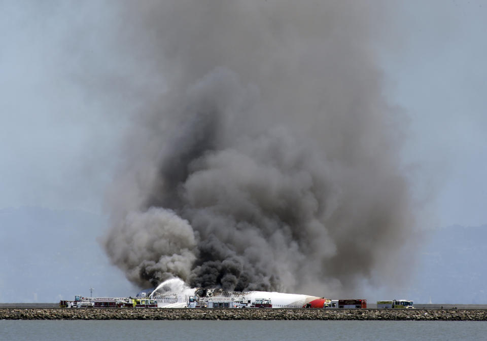 Smokes rises from Asiana Flight 214 after it crashed at San Francisco International Airport in San Francisco, Saturday, July 6, 2013. (AP Photo/Bay Area News Group, John Green)