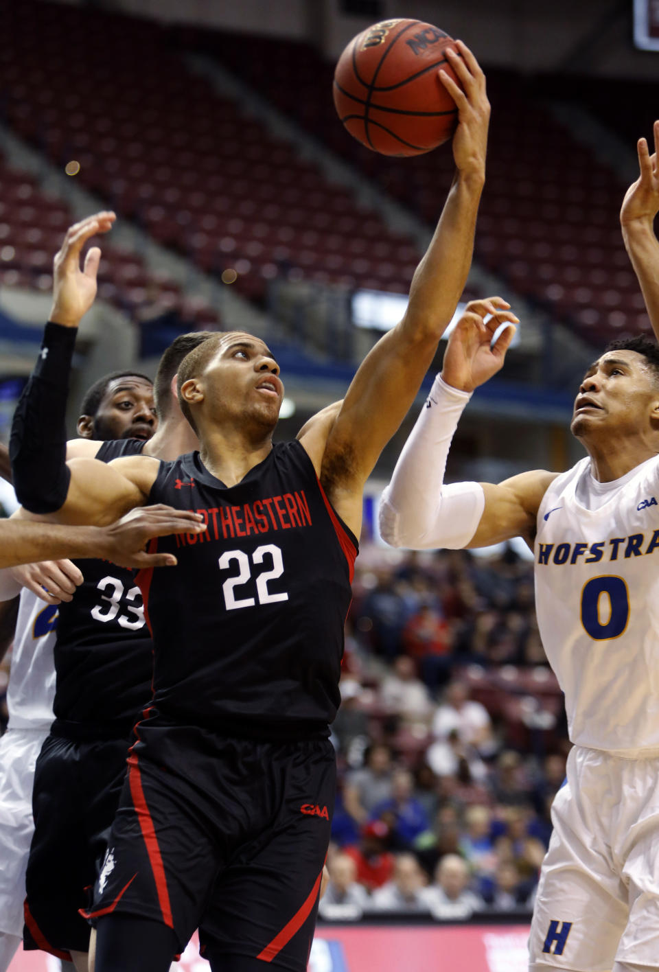 Northeastern's Donnell Gresham Jr. (22) grabs a rebound against Hofstra's Tareq Coburn (0) in the first half of an NCAA college basketball game at the Colonial Athletic Association men's basketball championship, Tuesday, March 12, 2019, in North Charleston, S.C. (AP Photo/Mic Smith)