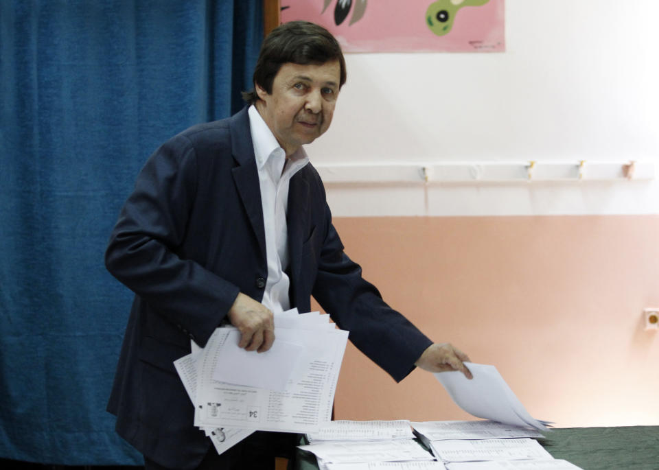 FILE - In this Thursday, May 4, 2017 file photo, Said Bouteflika, the brother of Algerian President Abdelaziz Bouteflika, takes ballots before voting in Algiers. The influential younger brother of Algeria's former longtime president was detained Saturday May 4, 2019, for questioning along with two generals who previously ran state security agencies, a security official said. (AP Photo/Sidali Djarboub, File)