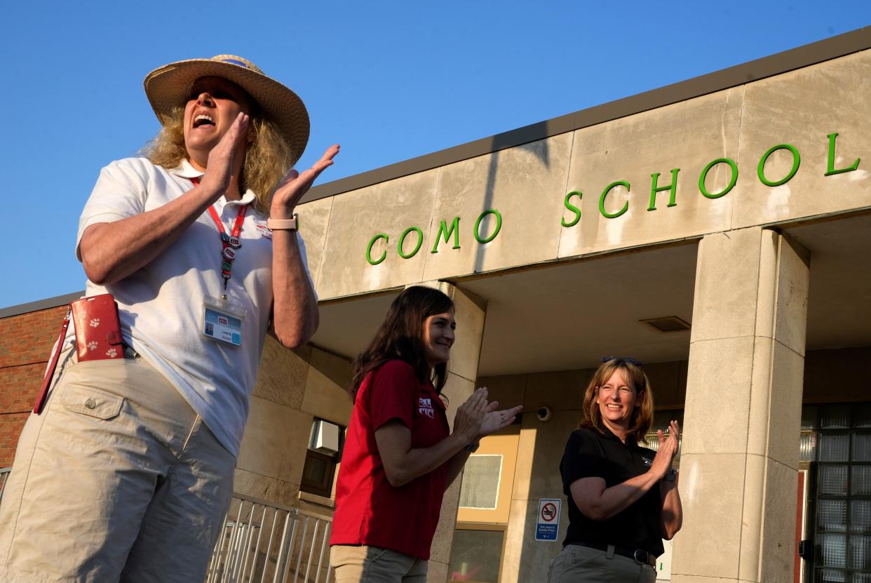 Volunteers from the Columbus Zoo & Aquarium (right to left) Linda Butler, Monica Tuttle and Becky Nellis "clap in" teachers and students in front of Como Elementary School to welcome them on the first day of the 2023-24 school year on Wednesday, Aug. 23, 2023, for most Columbus City Schools students.