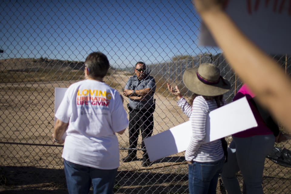 In this Nov. 15, 2018 photo provided by Ivan Pierre Aguirre, protesters talk to a guard inside the Tornillo detention camp holding more than 2,300 migrant teens in Tornillo, Texas. The Trump administration announced in June 2018 that it would open the temporary shelter for up to 360 migrant children in this isolated corner of the Texas desert. Less than six months later, the facility has expanded into a detention camp holding thousands of teenagers - and it shows every sign of becoming more permanent. (Ivan Pierre Aguirre via AP)