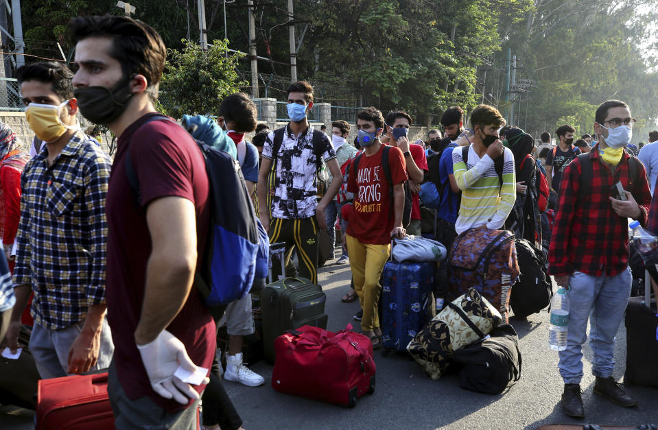 Kashmiris, mostly students, stranded for weeks wait to board buses to a special train home during a lockdown to curb the spread of new coronavirus, in Bangalore, India, Sunday, May 10, 2020. India's lockdown entered a sixth week on Sunday, though some restrictions have been eased for self-employed people unable to access government support to return to work. (Aijaz Rahi)
