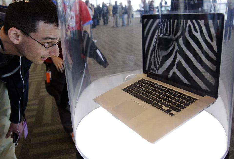 An attendee looks at the new MacBook Pro on display at the Apple Developers Conference in San Francisco, Monday, June 11, 2012. New iPhone and Mac software and updated Mac computers were among the highlights Monday at Apple Inc.'s annual conference for software developers. (AP Photo/Paul Sakuma)