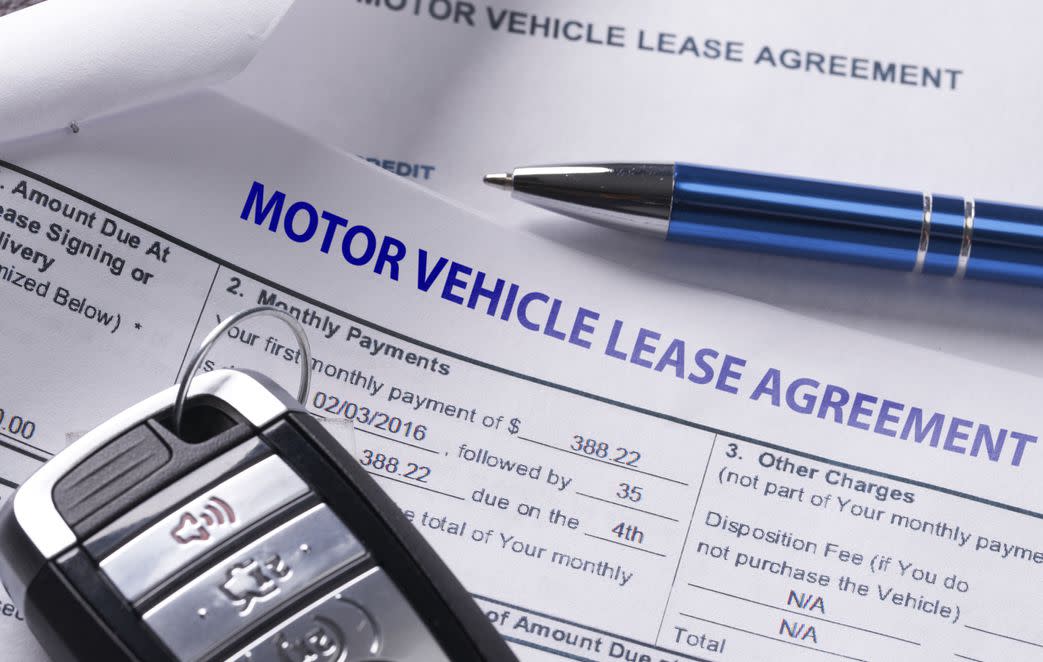 Automobile lease agreement document with key and pen on contract