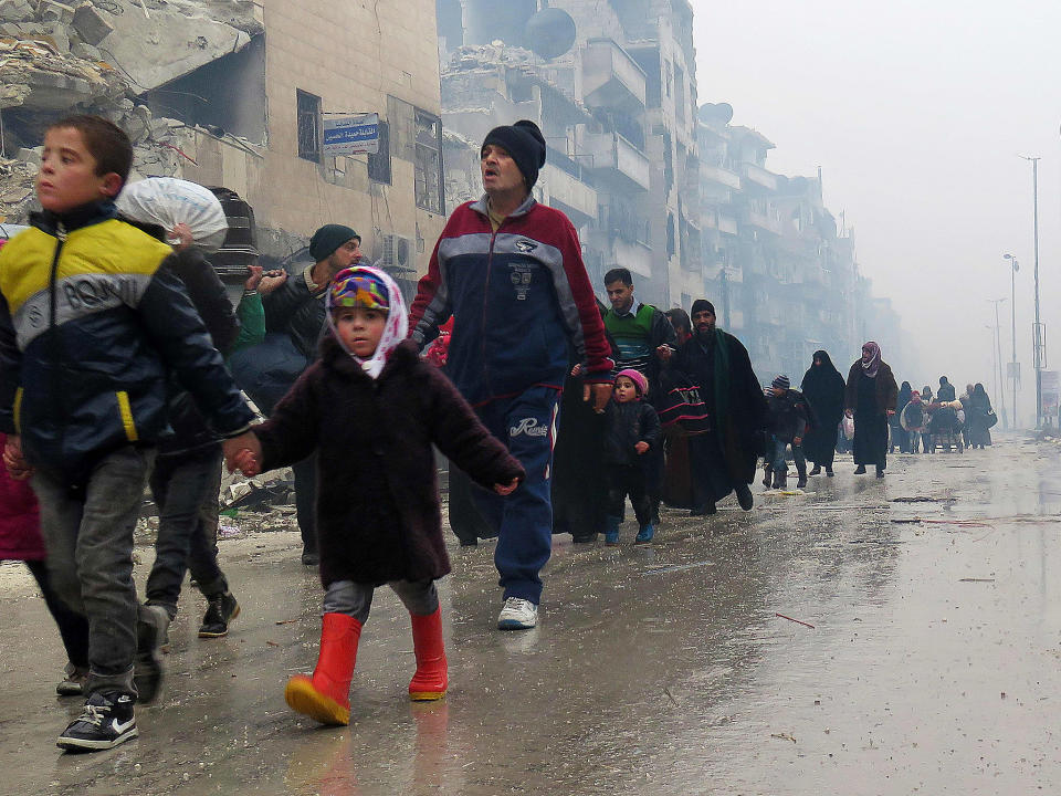 Syrian residents, fleeing violence in the restive Bustan al-Qasr neighbourhood, arrive in Aleppo's Fardos neighbourhood, after regime troops retook the area from rebel fighters: Getty