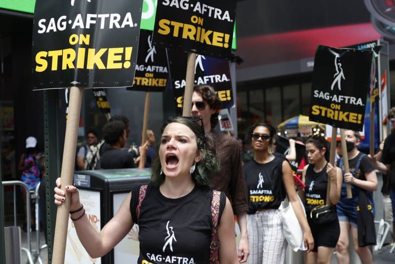 Members of the Writers Guild of America East are joined by SAG-AFTRA members and actors as they hold up signs picketing in Times Square in New York City on July 14. File Photo by John Angelillo/UPI