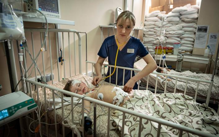 A medic tends to an injured boy at Zaporizhzhia Regional Clinical Children's Hospital - Simon Townsley