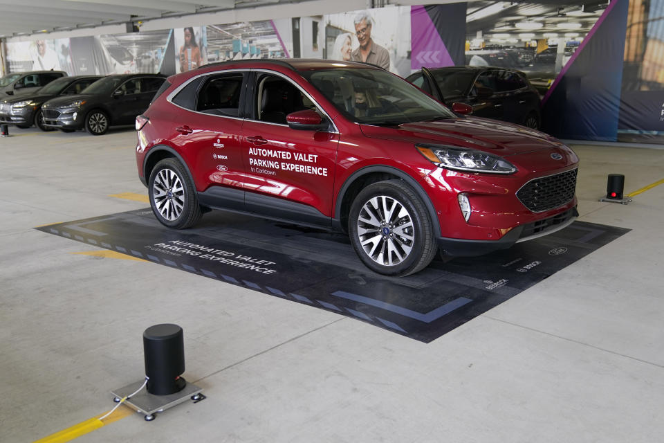 A Ford Escape is seen on a starting block before floor sensors help navigate the vehicle to self park, Tuesday, Aug. 25, 2020 in Detroit. Ford, Bosch and real estate company Bedrock are teaming up to test technology that will let vehicles park by themselves in parking decks. The companies are testing the technology using floor-mounted sensors and computers that can control mainly existing features in the Ford Escape. They say the technology is likely to arrive before widespread use of fully autonomous vehicles because sensors and computers inside parking decks can be used. (AP Photo/Carlos Osorio)