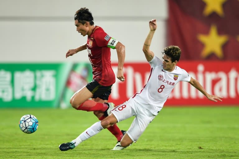 Shanghai SIPG's Oscar (R) fights for the ball with Guangzhou Evergrande's Zheng Zhi during their AFC Champions League quarter-final match, in Guangzhou, on September 12, 2017