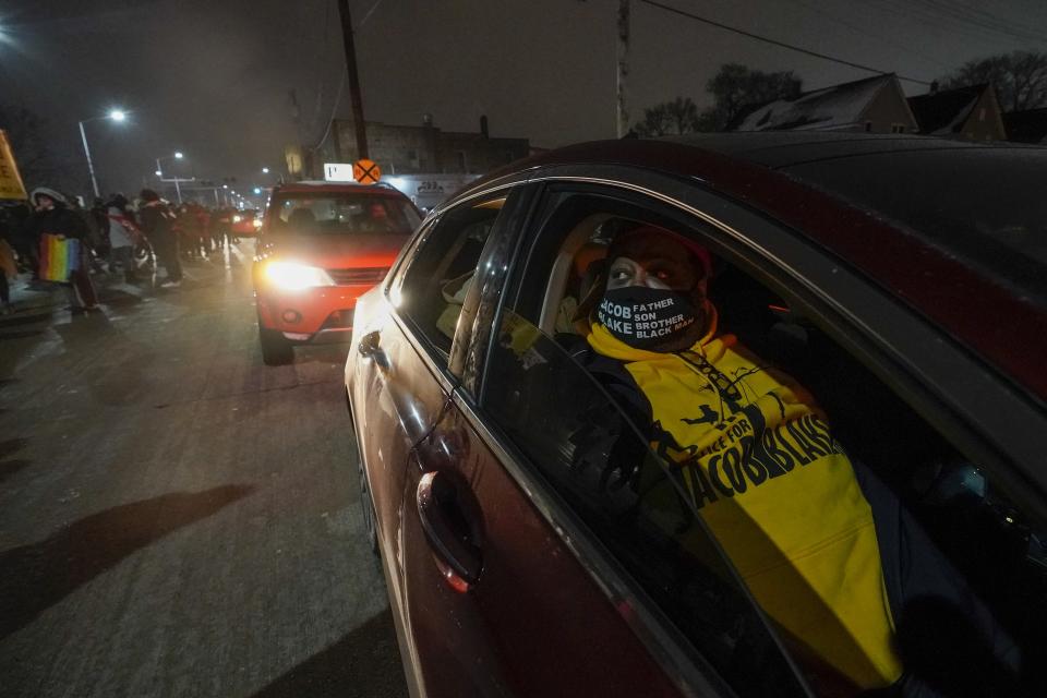 Jacob Blake Sr., father of Jacob Blake, rides in a car while supporters march at a rally Monday, Jan. 4, 2021, in Kenosha, Wis. (AP Photo/Morry Gash)