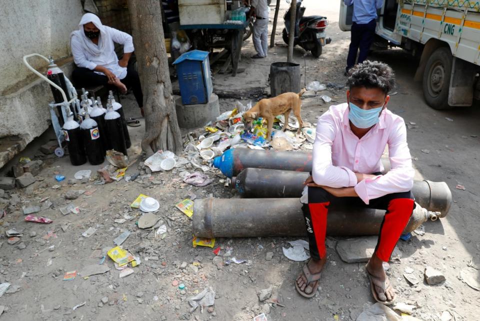 <div class="inline-image__caption"><p>Sumit Kumar, 28, sits on an oxygen cylinder as he waits outside a factory to get it refilled in New Delhi, India, April 28 2021.</p></div> <div class="inline-image__credit">REUTERS/Adnan Abidi/File Photo</div>