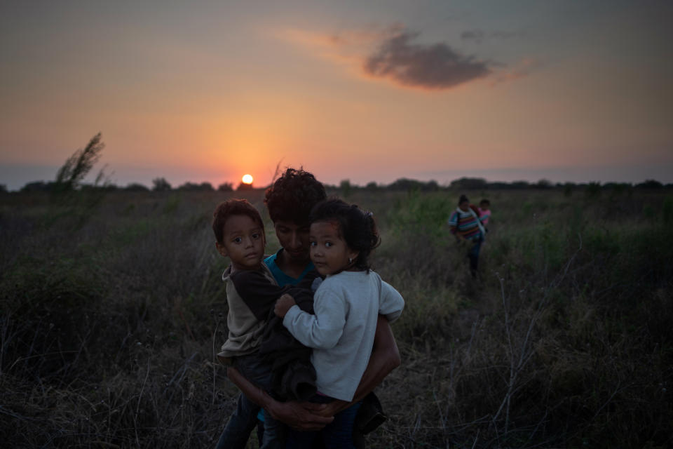 In Penitas, Texas, Luis from Honduras holds his 3-year-old son Eduardo and a 4-year-old girl Montserrat, the daughter of the woman in the background, after a group of nearly two dozen migrants from Central America illegally crossed the Rio Grande River into the United States from Mexico, Nov. 7, 2018. (Photo: Adrees Latif/Reuters)