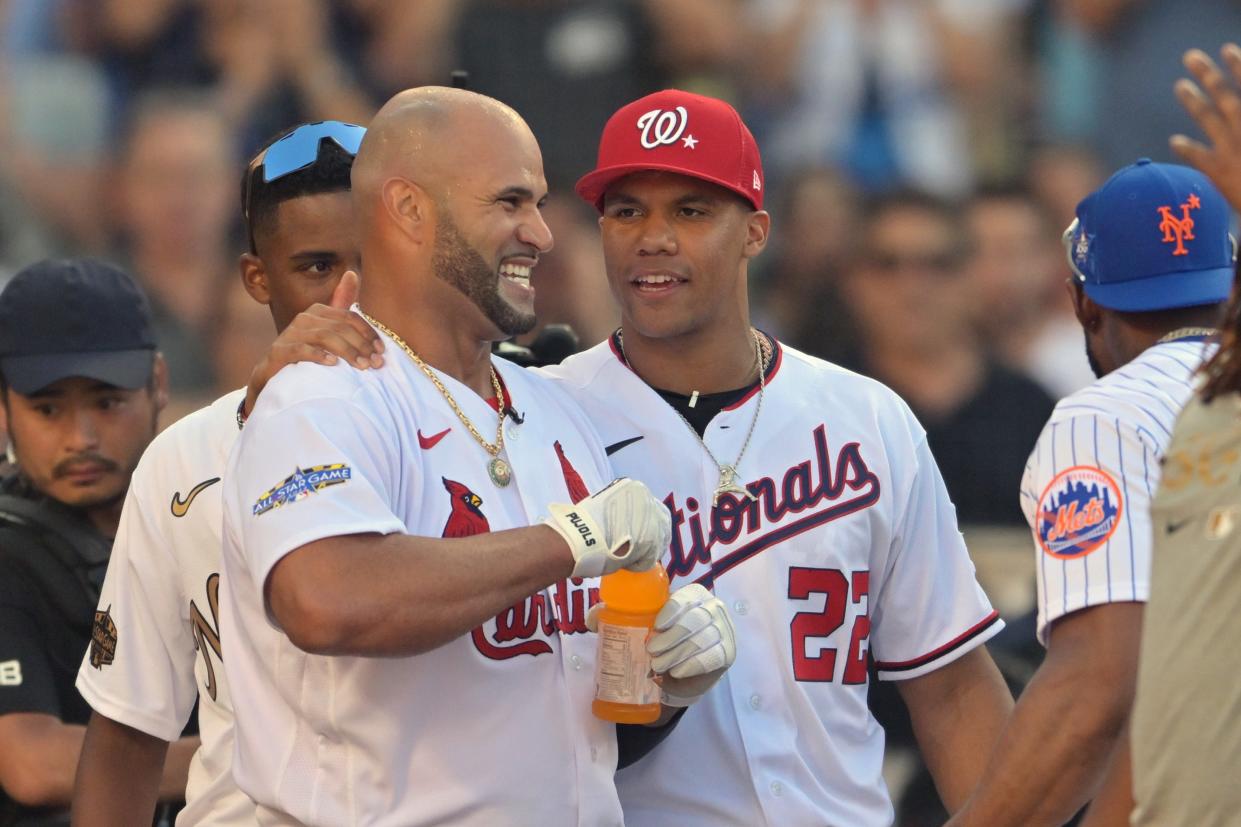 The St. Louis Cardinals' Albert Pujols takes a time out in the first round and meets with players, including the Washington Nationals ' Juan Soto.