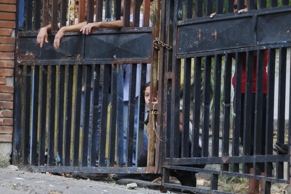 Residents watch anti-government protesters clash with security forces as some residents show support for an apparent mutiny by a national guard unit in the Cotiza neighborhood of Caracas, Venezuela, Monday, Jan. 21, 2019. (AP Photo/Fernando Llano)