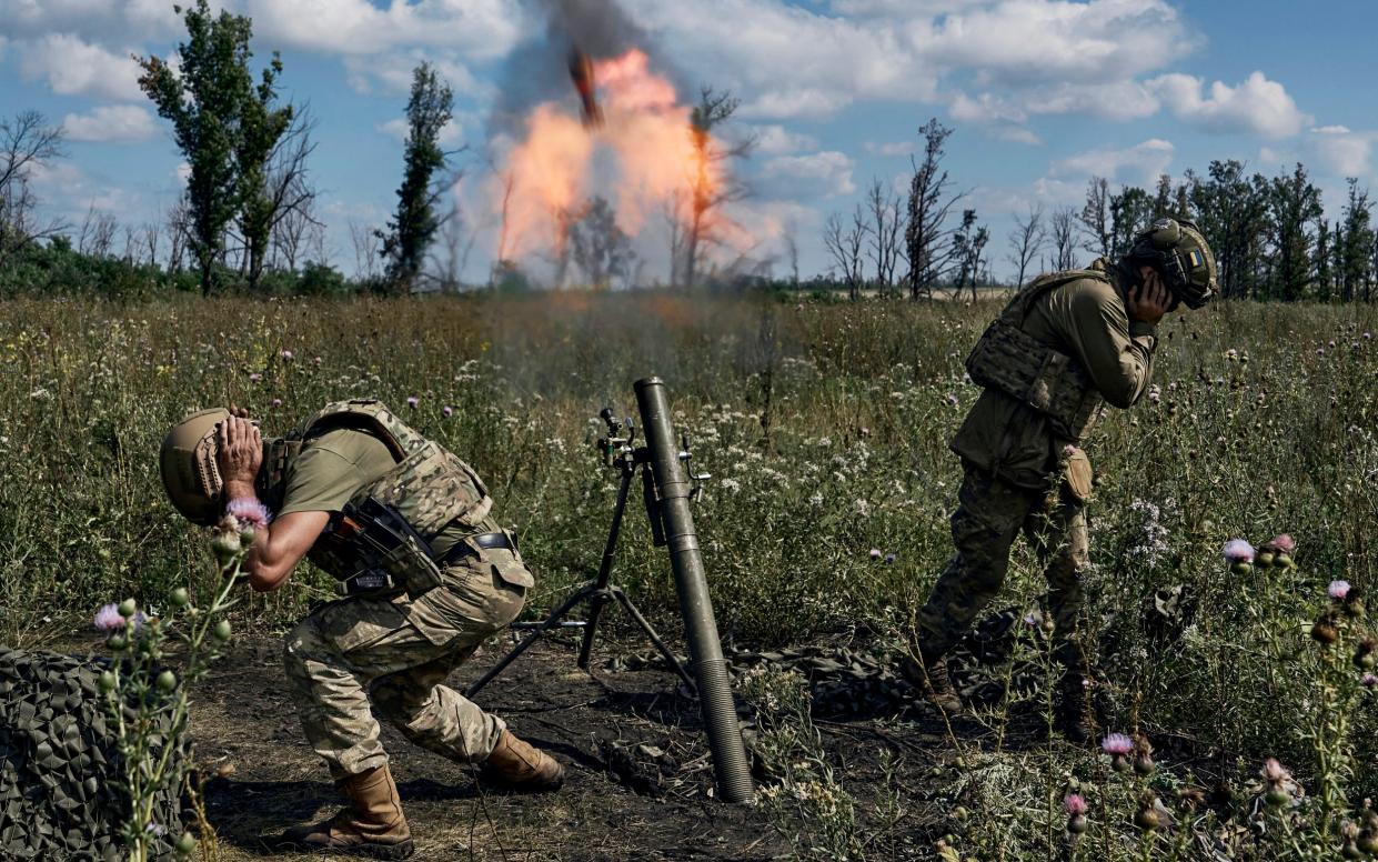 Ukrainian soldiers fire a mortar towards Russian positions at the front line, near Bakhmut, Donetsk