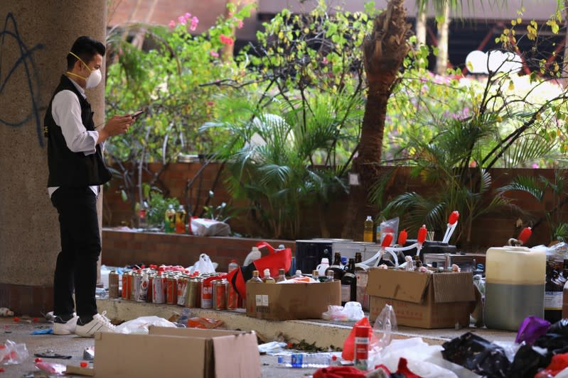 Police and firefighting personnel move Molotov cocktails, flammable materials and liquids into a corner, inside the Hong Kong Polytechnic University (PolyU) in Hong Kong, China