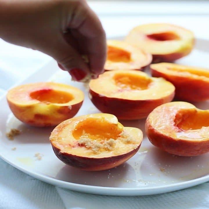 Sprinkling peaches with brown sugar.