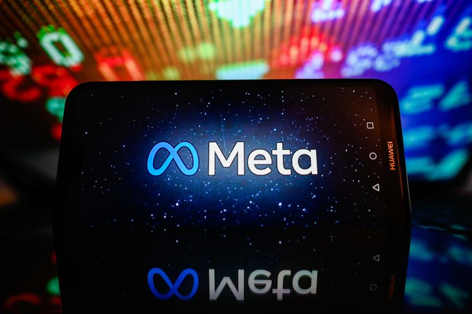 In this photo illustration, a Meta logo is displayed on a smartphone with stock market percentages in the background.