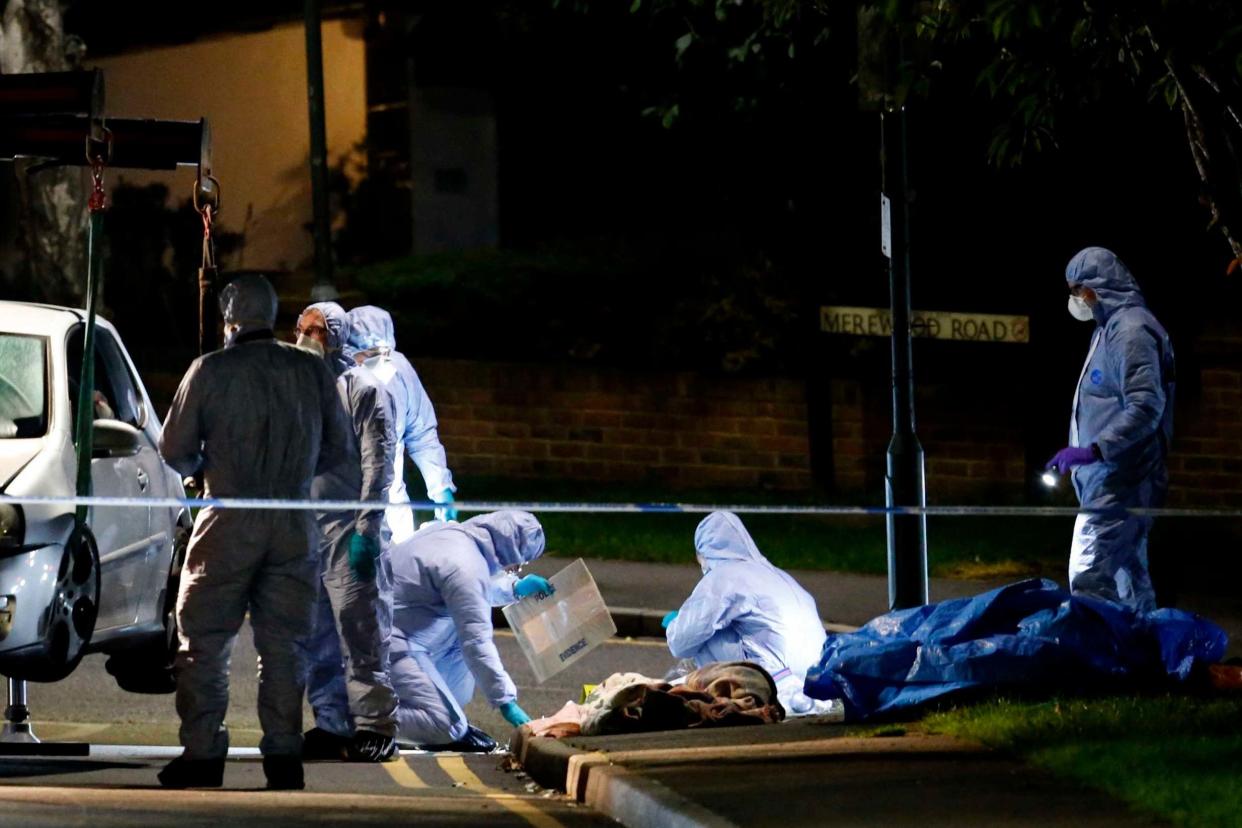 A file image of forensic officers in Barnehurst Avenue, Bexley, earlier this week after 20-year-old Ben Lines was stabbed to death. There were more than 15,000 knife offences in the year up to June: Nigel Howard/Evening Standard