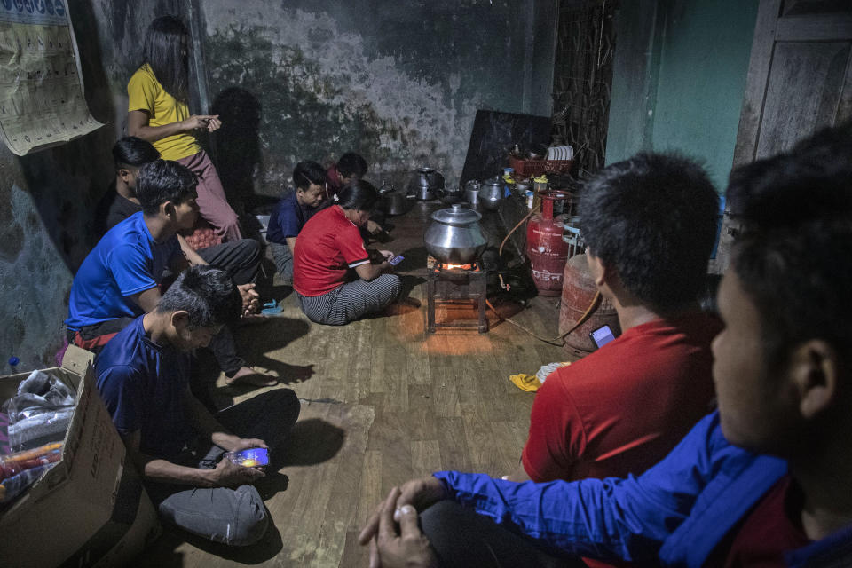 Police officers who fled Myanmar following a military coup sits for a meal at an undisclosed location bordering Myanmar, in the northeastern Indian state of Mizoram, Thursday, March 18, 2021. Villagers in Mizoram have given shelter to 34 Myanmar police personnel and 1 fire fighter, who crossed over to the state over the last two weeks. Those who escaped spend their time watching local television and doing daily chores. Some of them have carried mobile phones and are trying to connect to families they were forced to leave behind. At night, all of them go to sleep on mattresses laid on the floor of a single room. (AP Photo/Anupam Nath)