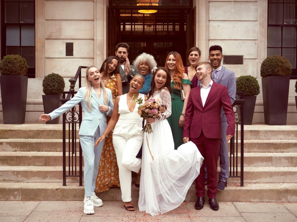 A wedding party smiles and poses for photos with married brides