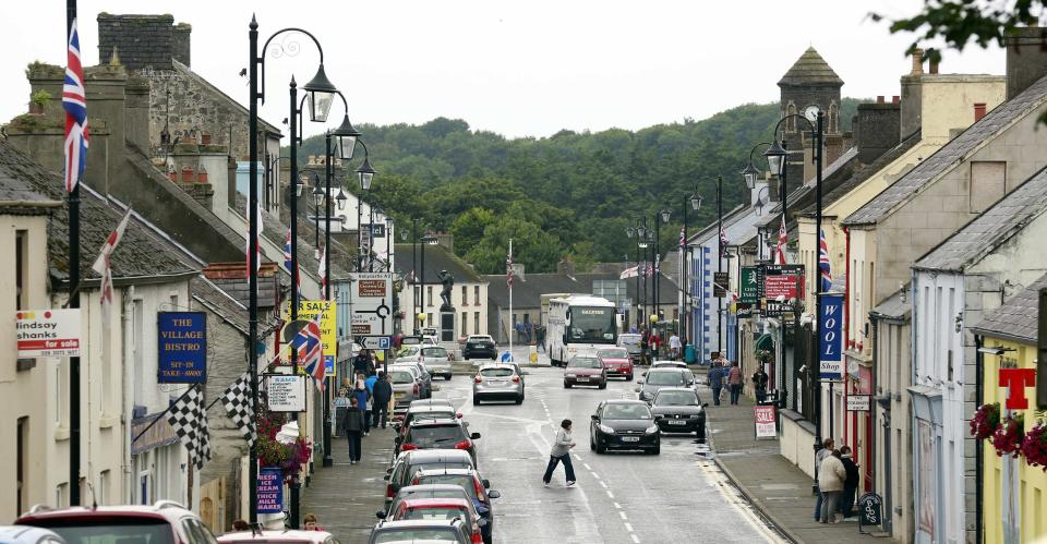 Woman walks across a street in the village of Bushmills on the Causeway Coast