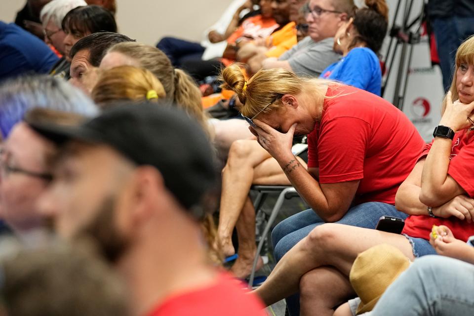 The public in attendance reacts as school closures and consolidation are announced during a meeting of the Columbus City Schools board June 25.