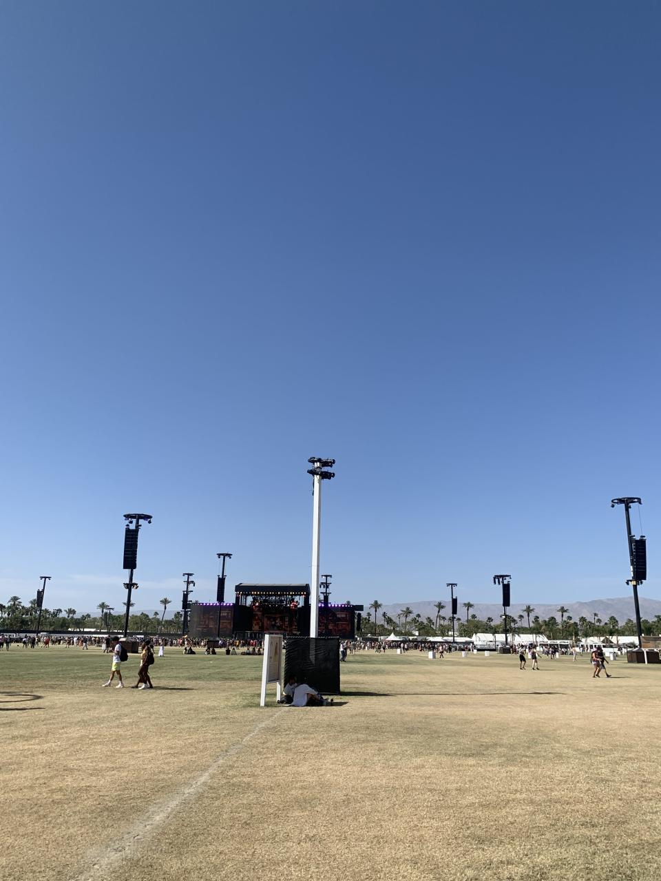 People sitting in the shade of a sign