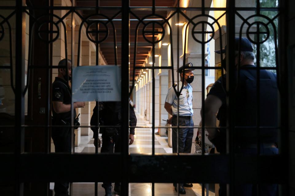 Police officers are seen at the entrance of Petraki Monastery (REUTERS)