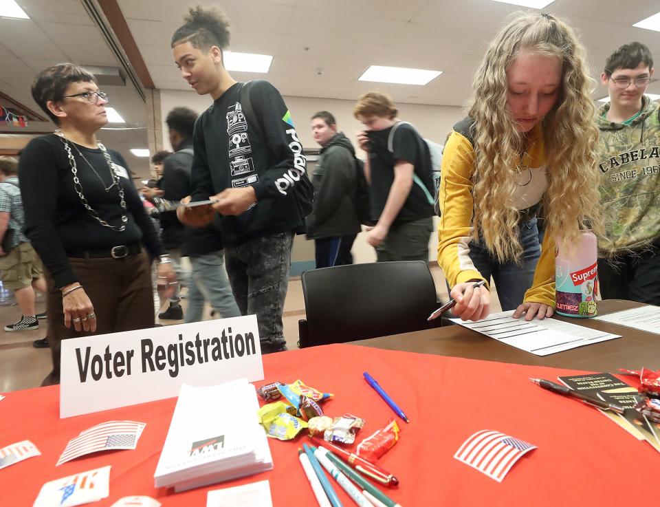 Kyla Anderson, 17, (right) registers to vote at Bremerton High School on Friday, Feb. 28, 2020.