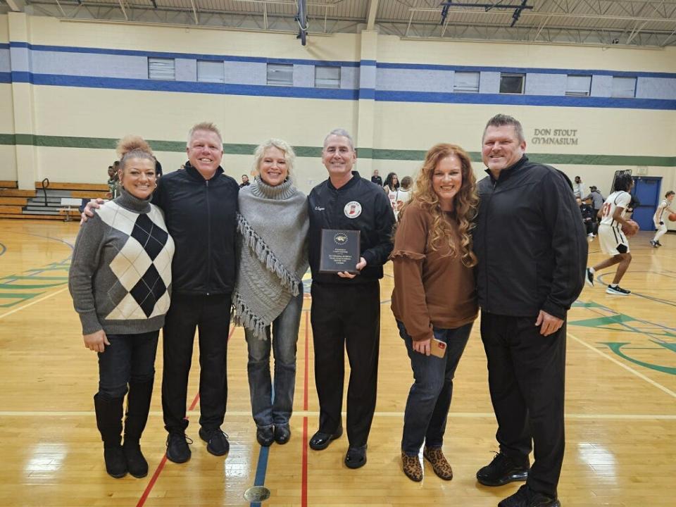 Casey Gaynor smiles with a plaque honoring his journey refereeing a game in every high school in the state on Tuesday, Jan. 2, 2023, at Municipal Gardens in Indianapolis.