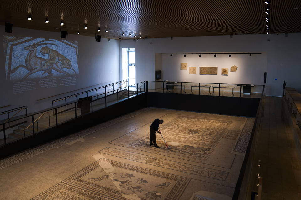 A worker cleans a restored Roman-era mosaic ahead of its display in its hometown ahead of the inauguration of the Shelby White & Leon Levy Lod Mosaic Archaeological Center, in Lod, central Israel, Thursday, June 23, 2022. A series of well-preserved ancient Roman mosaics have returned home to the central Israel city of Lod after more than a decade touring the world's most prominent museums. Israel on Monday inaugurated a new museum to house the artworks that once adorned a Roman-era villa. (AP Photo/Oded Balilty)