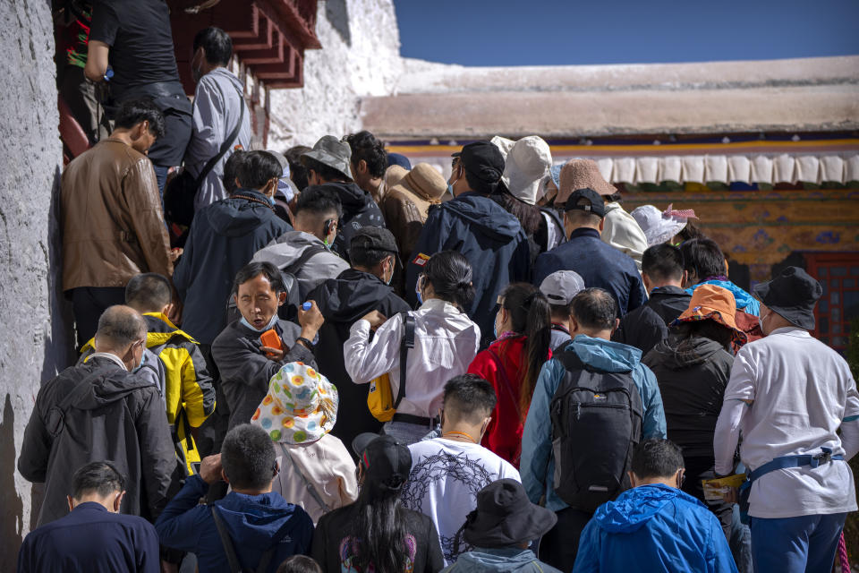 Tourists wait to climb steps to an interior area at the Potala Palace in Lhasa in western China's Tibet Autonomous Region, Tuesday, June 1, 2021. Tourism is booming in Tibet as more Chinese travel in-country because of the coronavirus pandemic, posing risks to the region's fragile environment and historic sites. (AP Photo/Mark Schiefelbein)