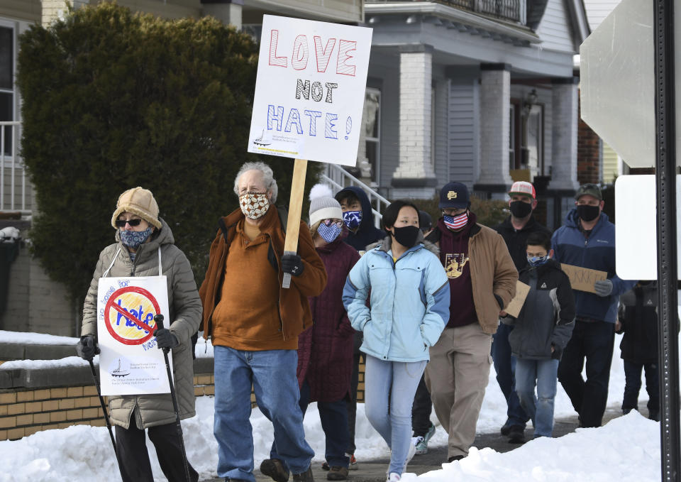 Chuck Palmer, 67, second from left, of Grosse Pointe Parks, walks south on Wayburn St. during the walking rally to protest hate and racism, Sunday, Feb. 21, 2021 in Grosse Pointe Park, Mich., following a white resident's display of a Ku Klux Klan flag in a side window facing their Black neighbor's home. JeDonna Dinges, 57, of Grosse Pointe Park, said the klan flag was hanging next door in a window directly across from her dining room. The incident occurred two weeks ago. (Clarence Tabb, Jr./Detroit News via AP)