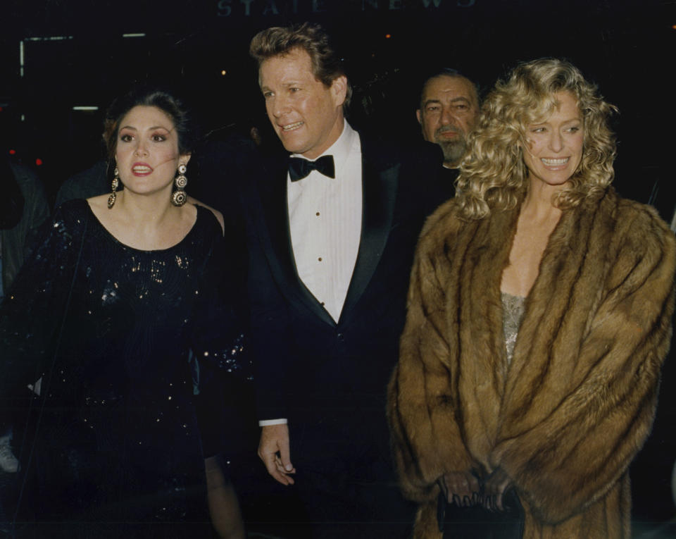 Actor Ryan O'Neal and longtime companion Farrah Fawcett arrive at the New York premiere of O'Neal's new movie, "Chances Are," March 6, 1989. Woman at left is unidentified. O’Neal, who was nominated for an Oscar for the tear-jerker “Love Story” and played opposite his precocious daughter Tatum in “Paper Moon,” has died. O’Neal's son Patrick said on Instagram that his father died Friday, Dec. 8, 2023. (AP Photo/Ray Stubblebine, File)