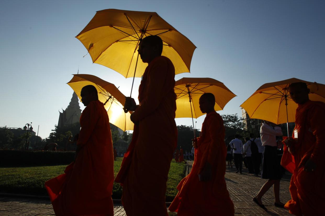 Cambodian Buddhist monks are silhouetted as they head to a ceremony in front of Royal Palace, in Phnom Penh, Cambodia, Wednesday, June 3, 2015. The ceremony celebrates Cambodia’s King Norodom Sihamoni’s new title as the &quot;Virtuous King for Propagation of Buddhism in the World” as given to him by the Nenbutsushu Buddhist sect of Japan.(AP Photo/Heng Sinith)