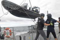 Members of Sea Shepherd, an ocean conservation group, lower an inflatable dinghy from the deck of the Ocean Warrior off the west coast of South America on July 17, 2021. Activists are seeking restrictions on fishing as part of negotiations underway on a first-ever High Seas Treaty, which could dramatically boost international cooperation on the traditionally lawless waters that comprise nearly half of the planet. (AP Photo/Joshua Goodman)